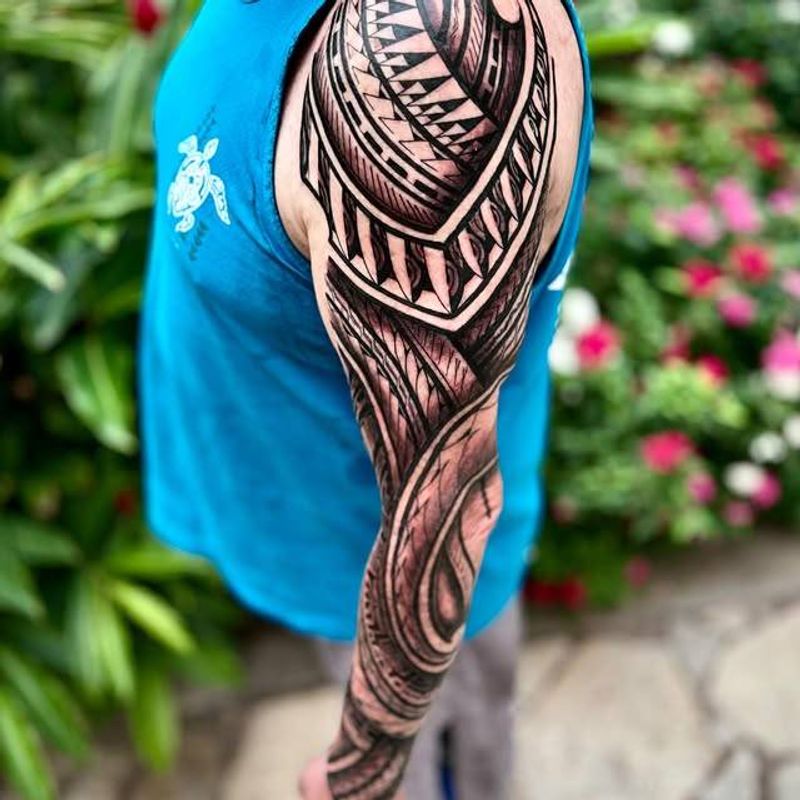 Black and grey tribal full sleeve tattoo on arm