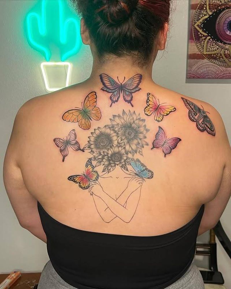 colorful butterflies and botanical tattoo on a person's back