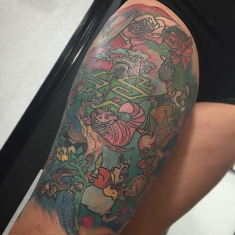 colorful alice in wonderland tattoo on thigh