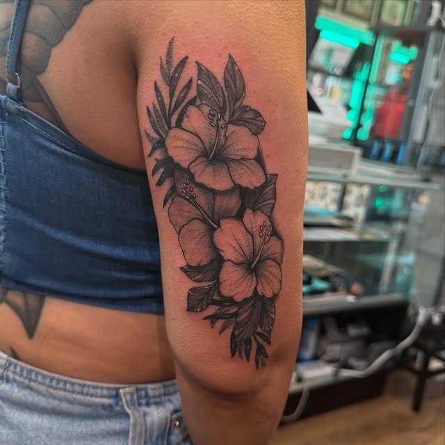 Black and grey floral tattoo on upper arm