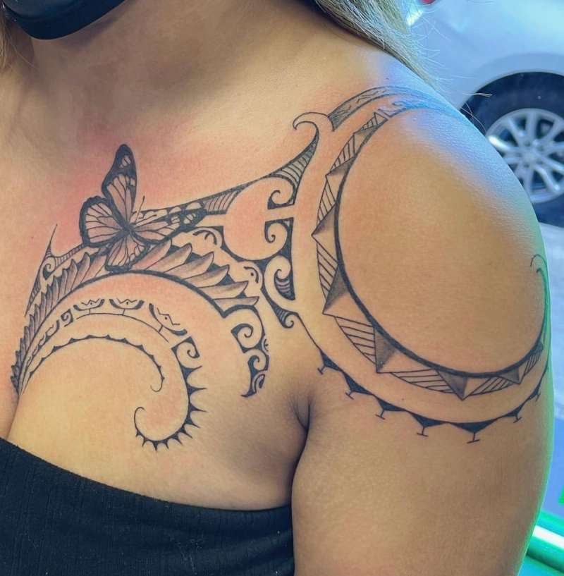 Black and grey tribal butterfly tattoo on shoulder