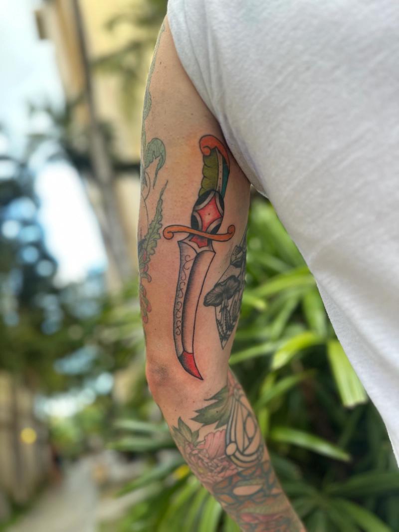 Colorful neo traditional dagger tattoo on upper arm