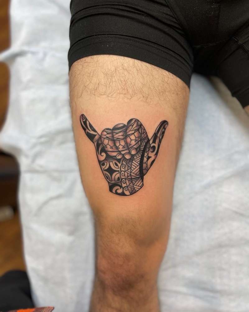 tribal style tattoo of a hand on a thigh