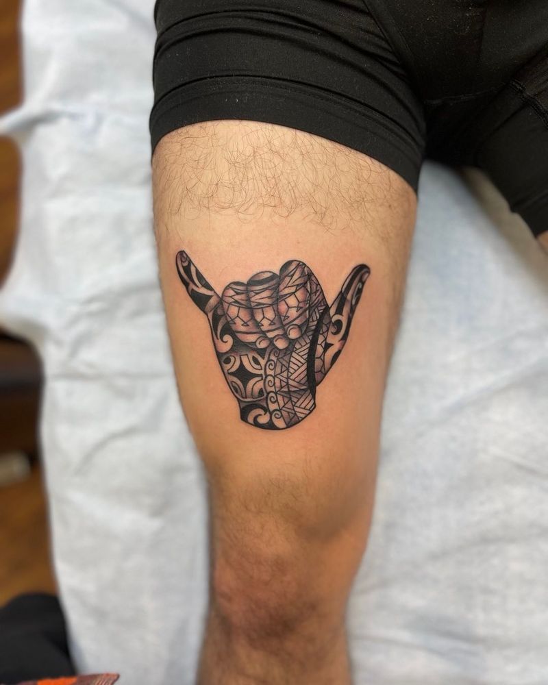tribal style tattoo of a hand on a thigh
