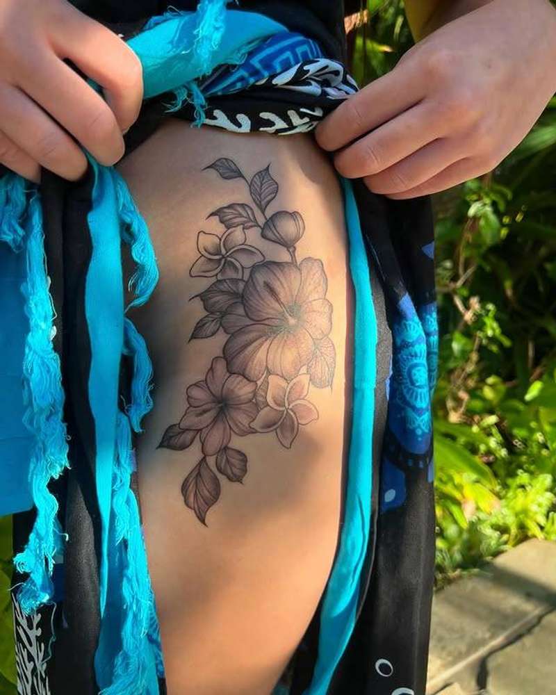 Black and grey botanical tattoo on thigh