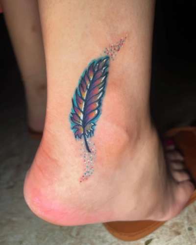 Small colorful feather tattoo on the foot