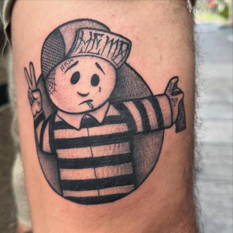 Black and grey cartoon character tattoo on thigh