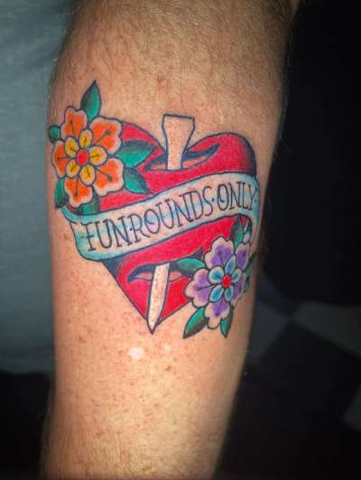 Colorful traditional heart and dagger tattoo with flowers on forearm