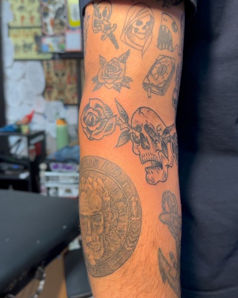 black and grey forearm tattoo with skull and rose
