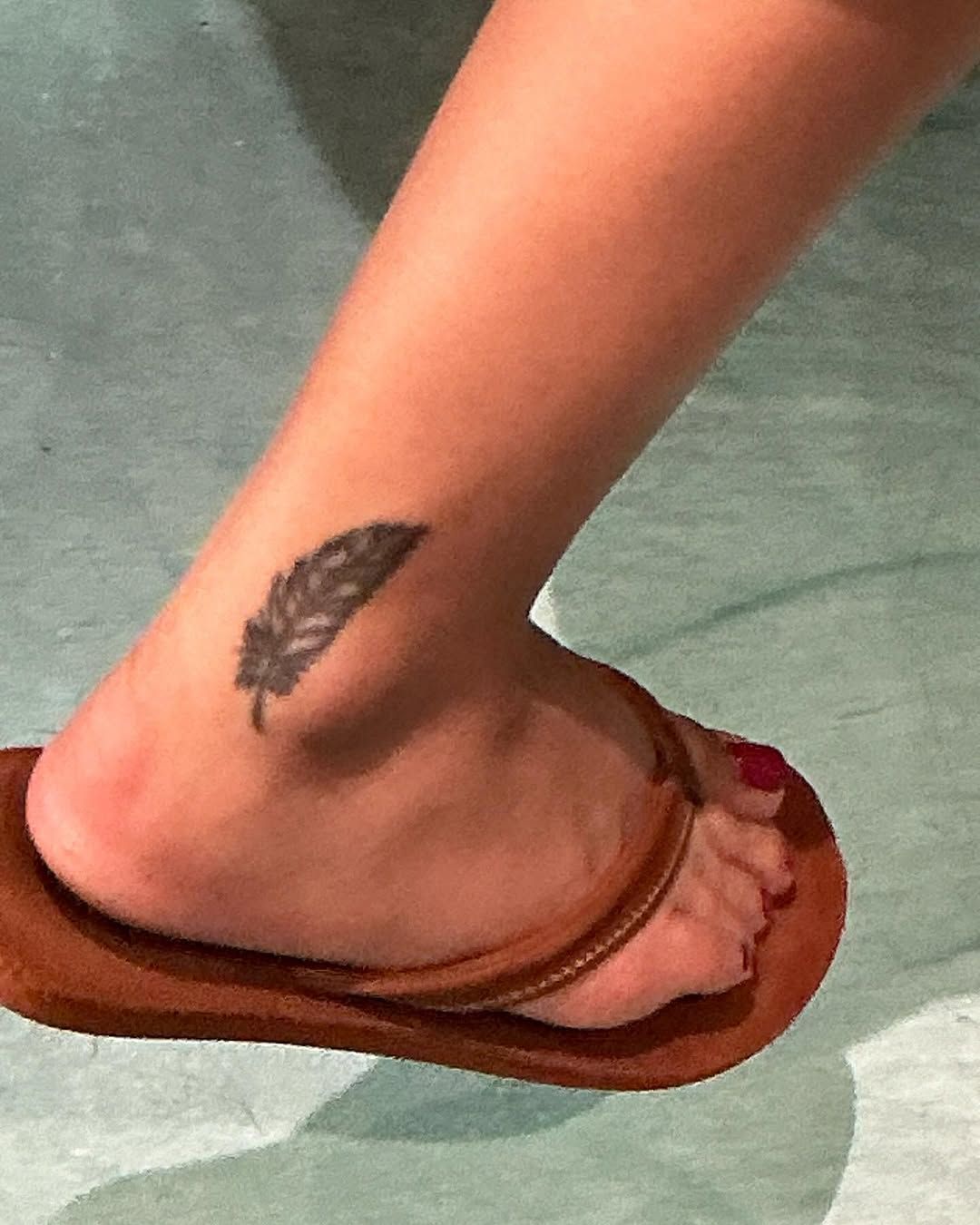 Black and grey feather tattoo on the ankle