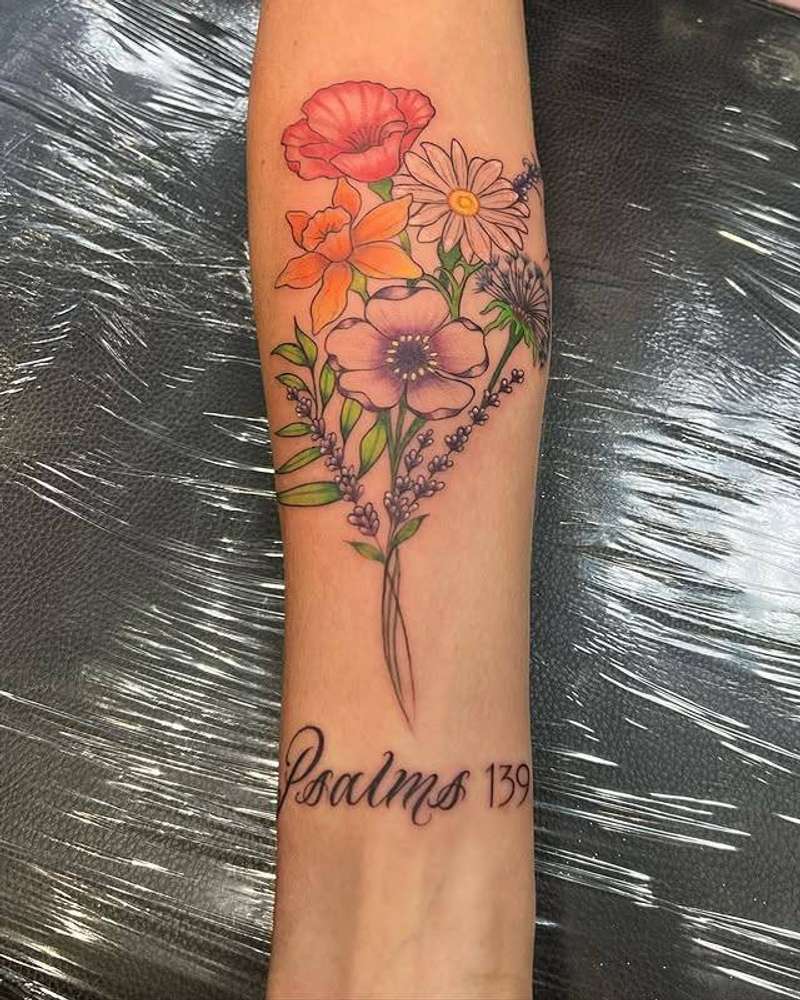 colorful floral tattoo with script on forearm