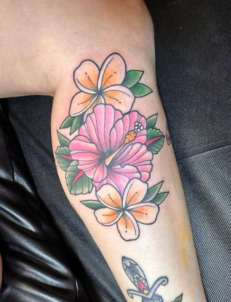 Colorful traditional flower tattoo on upper arm