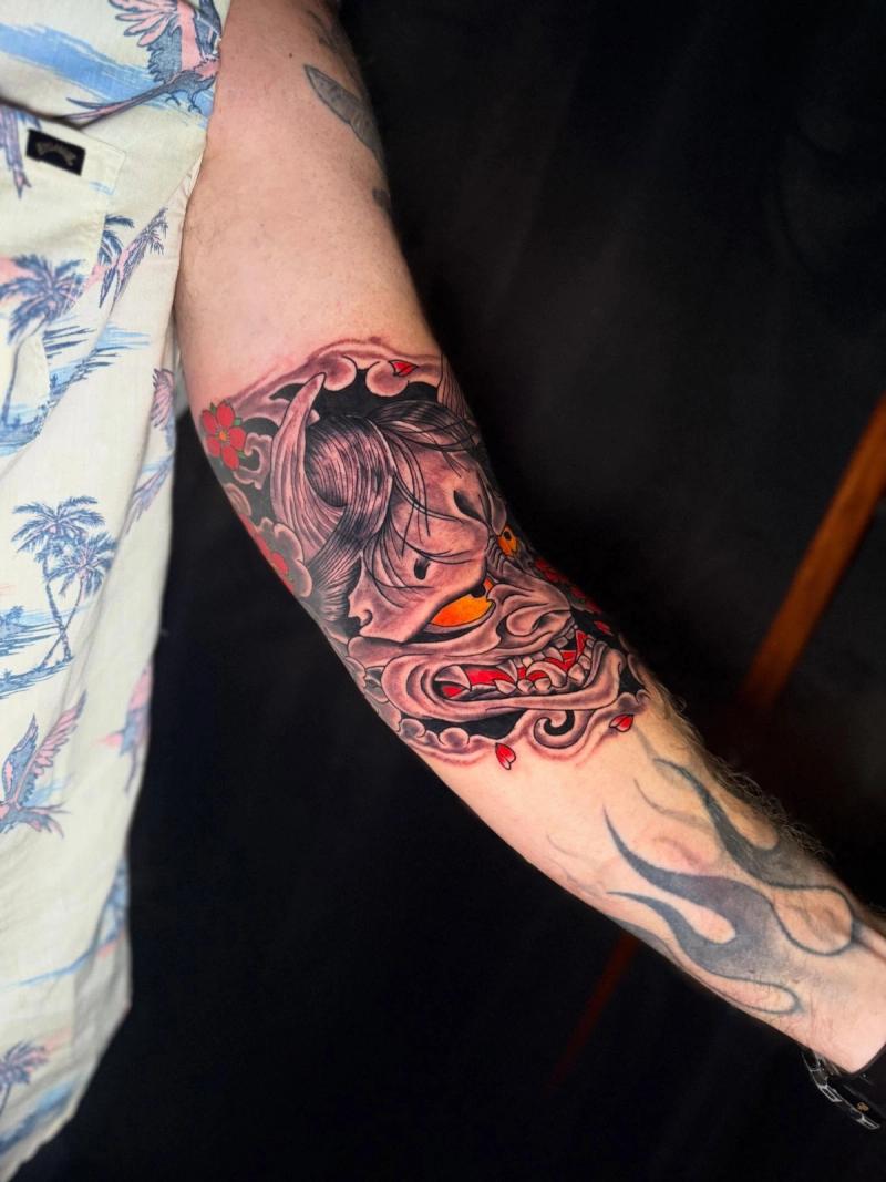 color japanese traditional forearm tattoo of oni demon mask with cherry blossoms