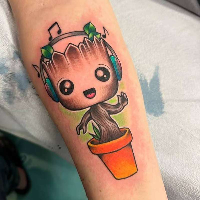Colorful cartoon character in pot tattoo on forearm