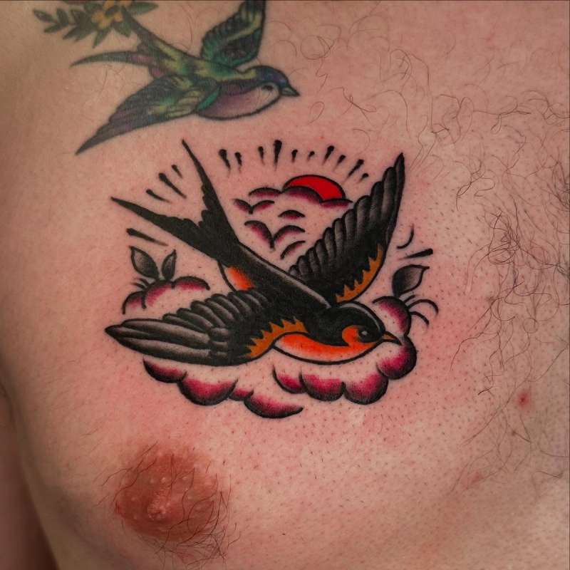 colorful traditional style bird tattoo on chest