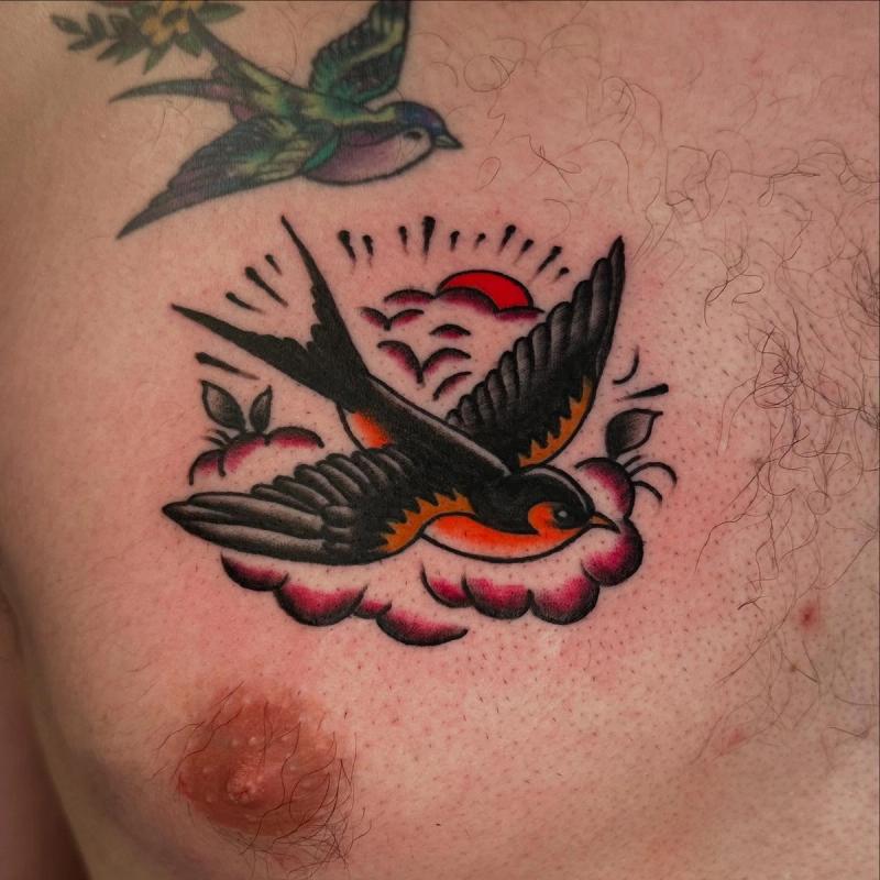 colorful traditional style bird tattoo on chest