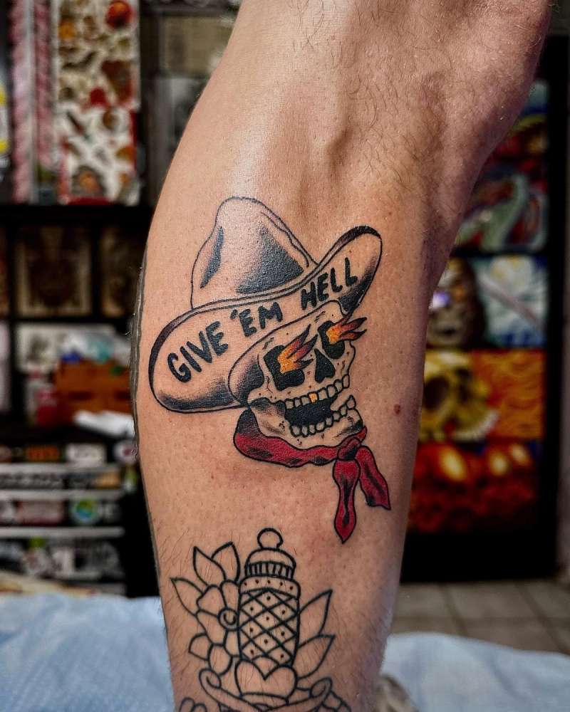 colorful cowboy skull tattoo with text on a calf