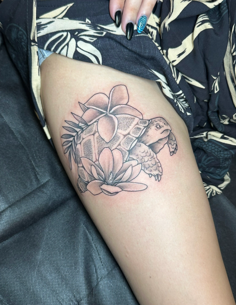 Black and grey turtle and flowers tattoo on thigh