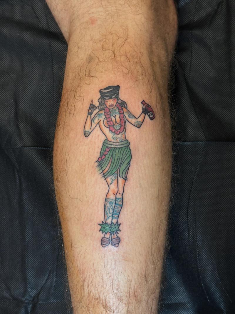 Colorful illustrative hula dancer tattoo on calf.