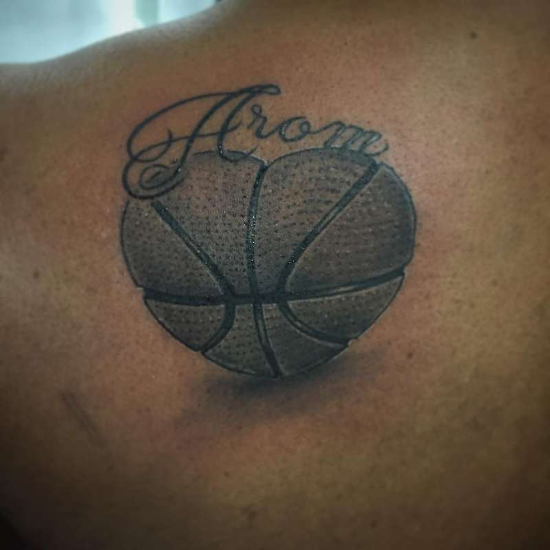 Black and grey basketball and script tattoo on upper back