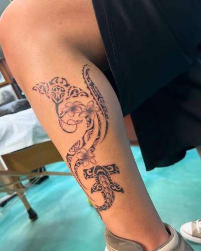 tribal floral tattoo on calf in black and grey