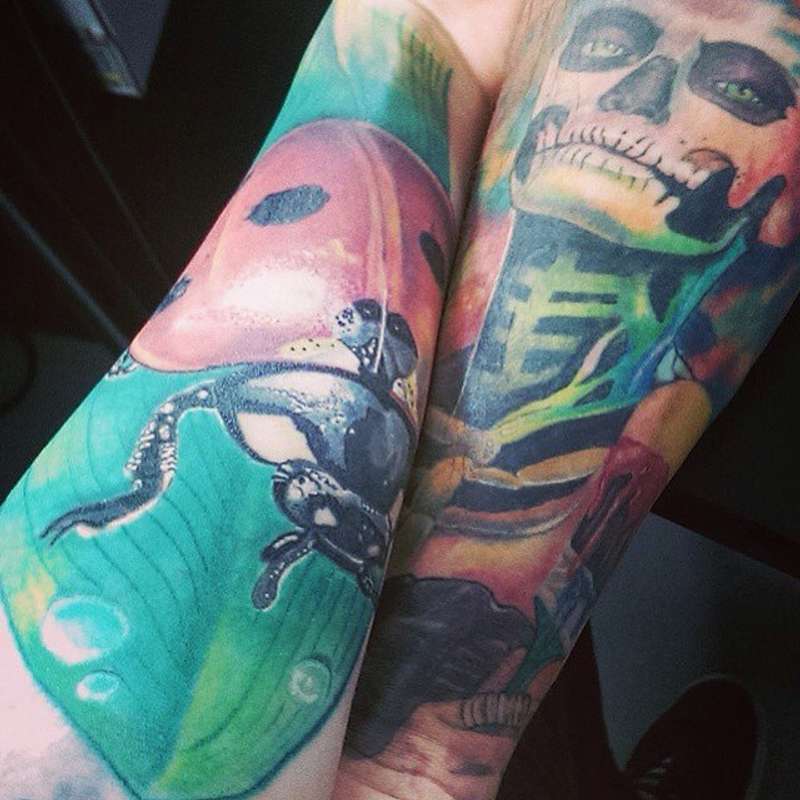 colorful arm tattoos with a skeleton and frog design