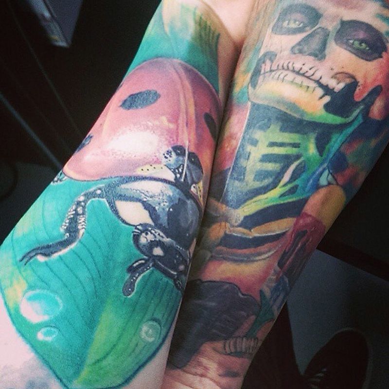 colorful arm tattoos with a skeleton and frog design