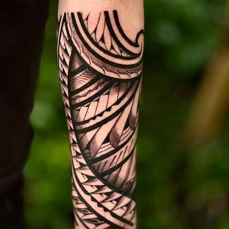 Blackwork geometric tattoo on forearm with intricate patterns and bold lines