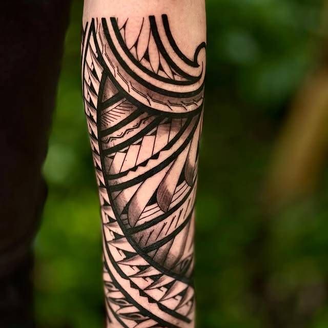 Blackwork geometric tattoo on forearm with intricate patterns and bold lines
