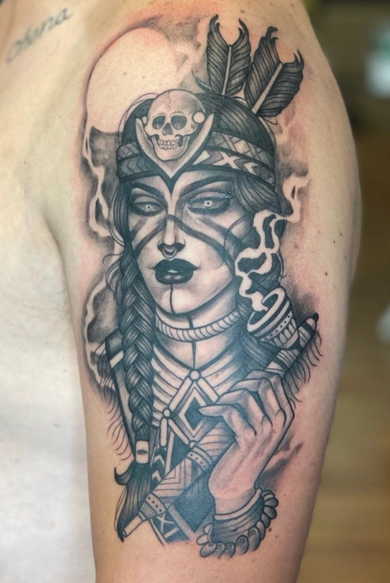 Black and grey tribal woman portrait tattoo on upper arm