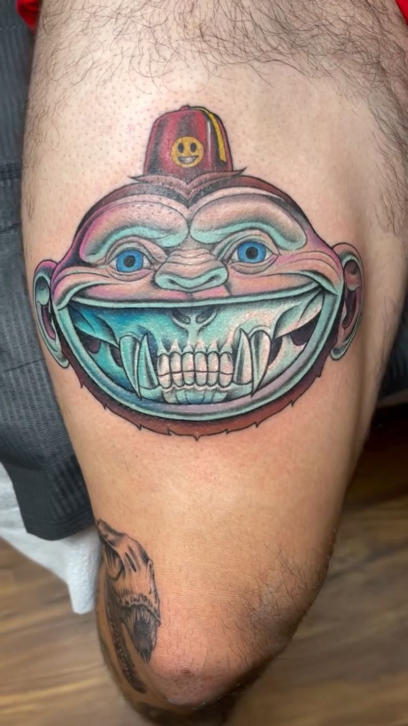 colorful tattoo of a smiling face on thigh