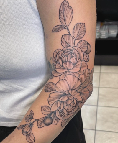 Black and grey floral tattoo on upper arm