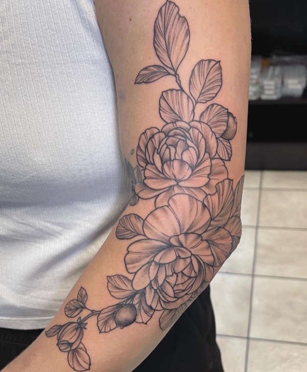 Black and grey floral tattoo on upper arm