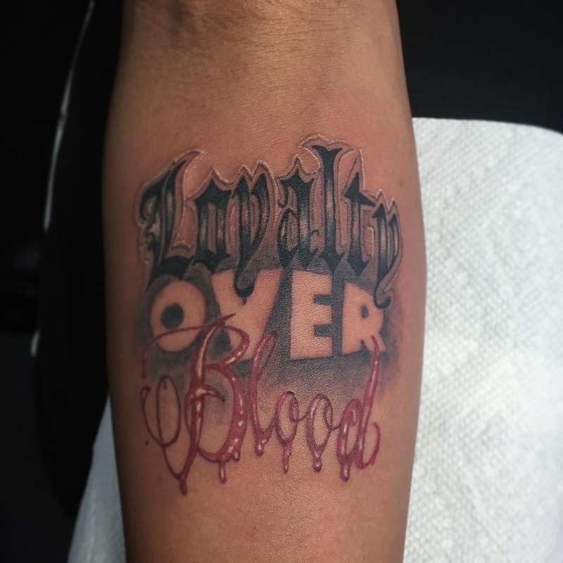 colorful lettering tattoo on forearm