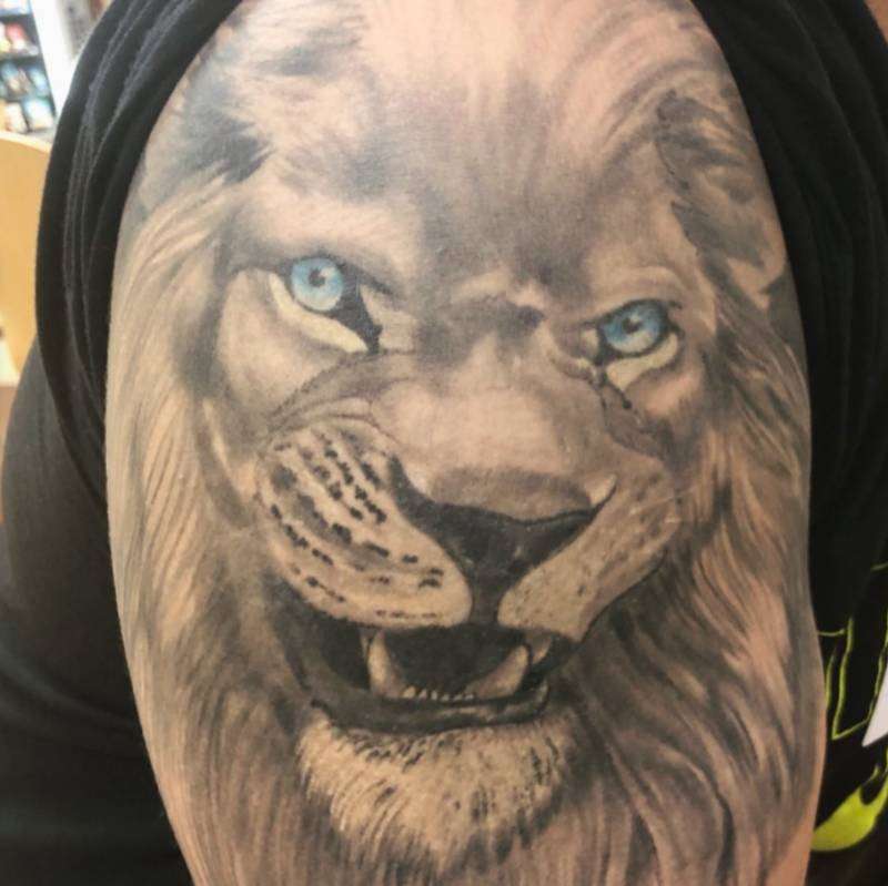realistic lion tattoo on upper arm