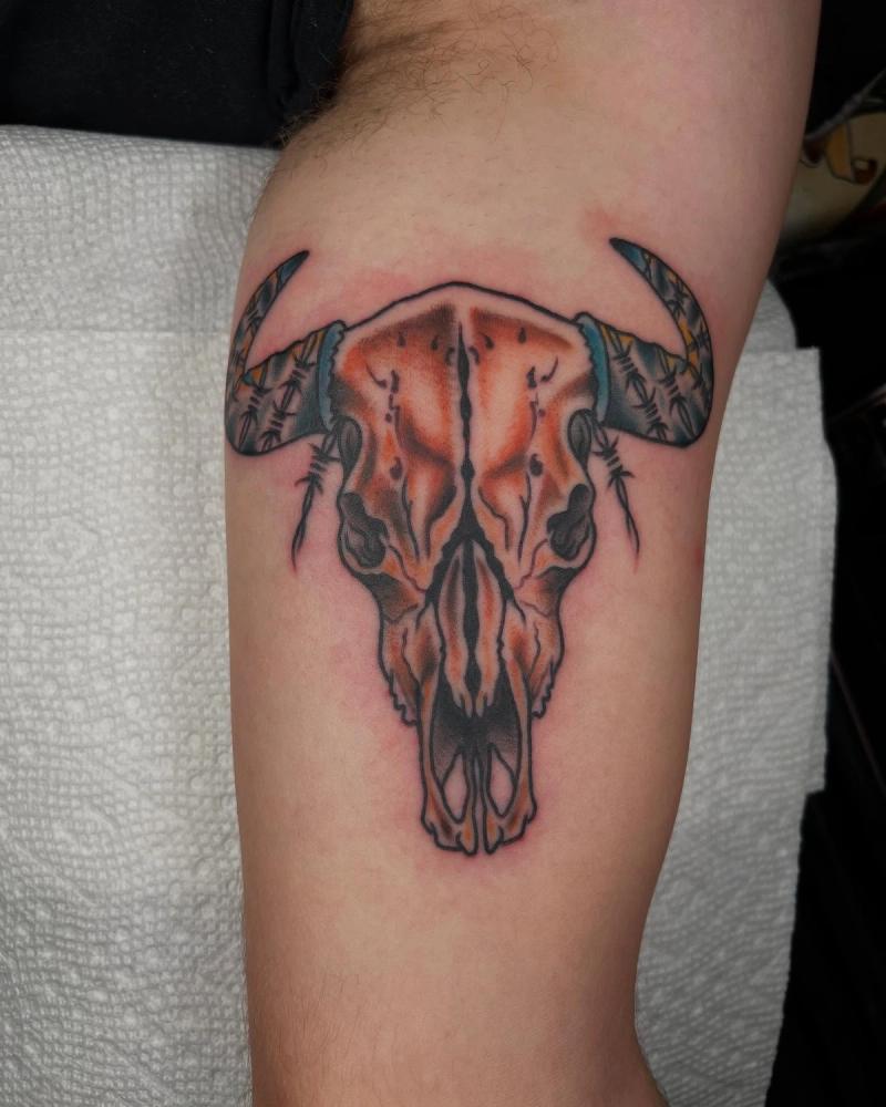 Colorful bull skull tattoo on upper arm.