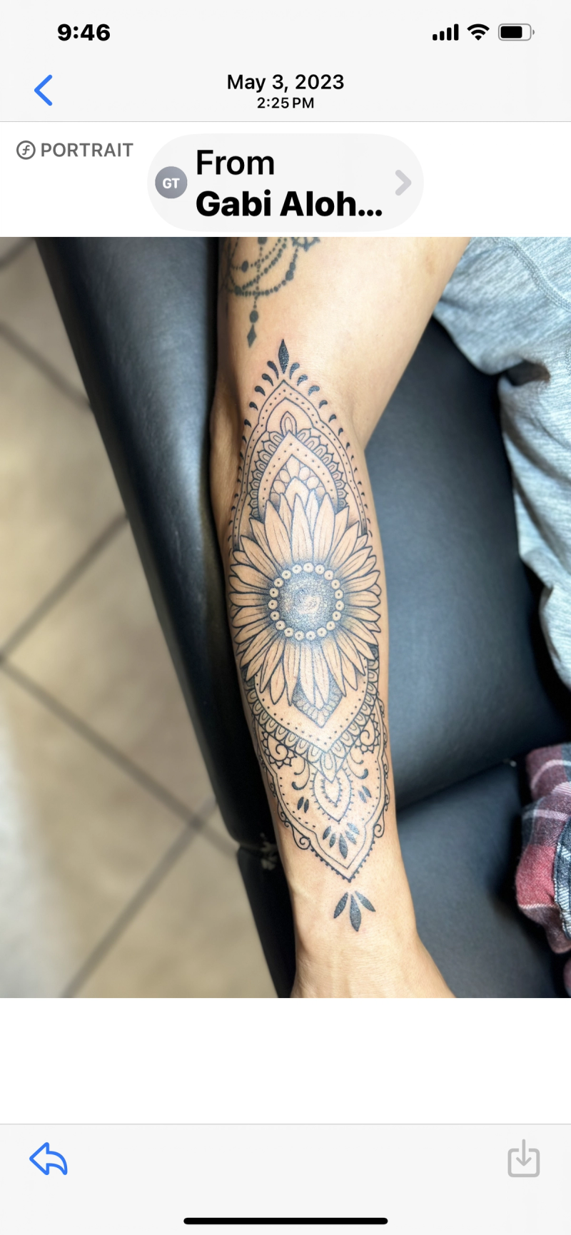 Black and grey geometric sunflower tattoo on forearm