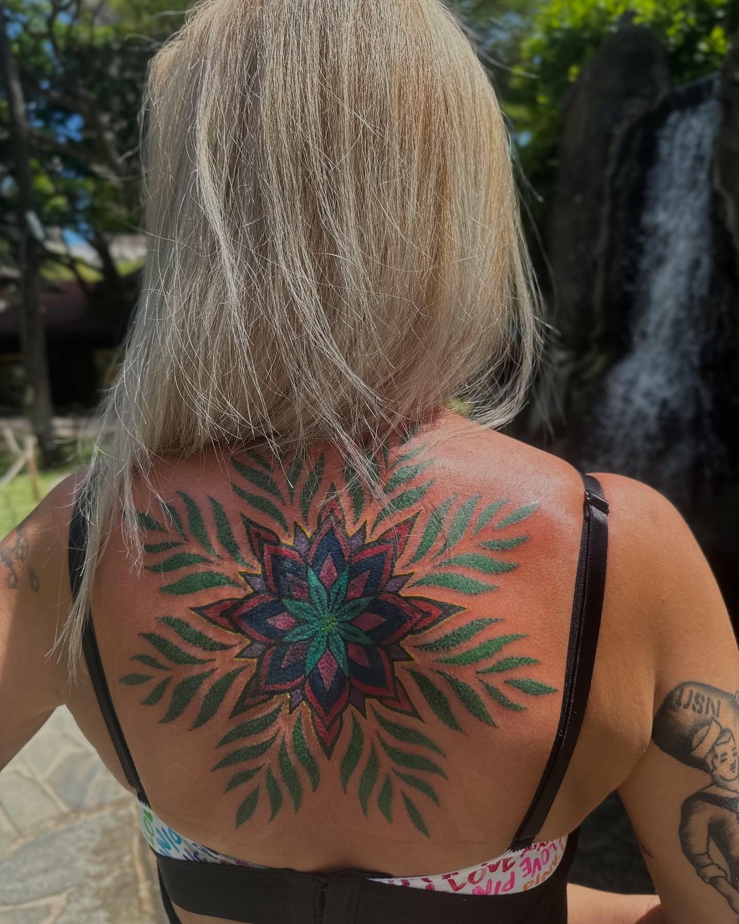Colorful geometric mandala tattoo on upper back