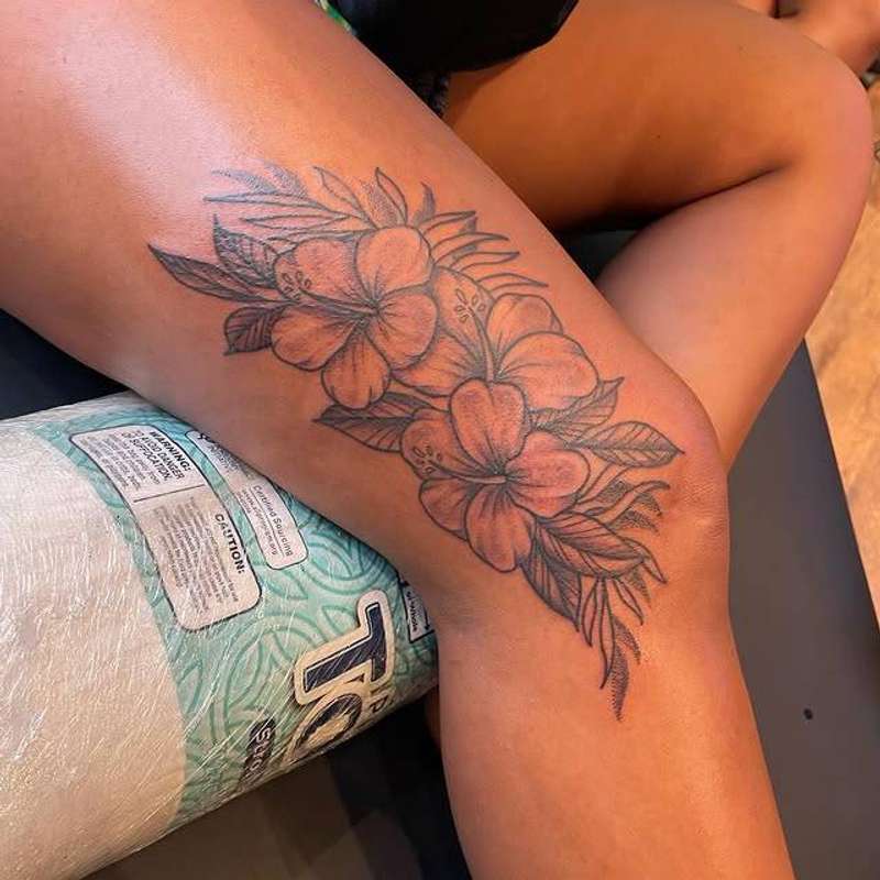 Black and grey floral tattoo on thigh