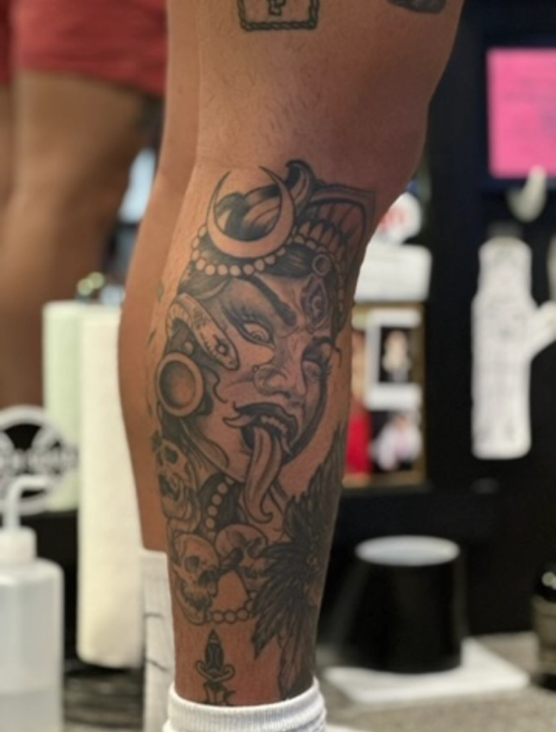 Black and grey demonic and skull tattoo on calf