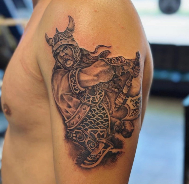 Black and grey realistic Viking warrior tattoo on upper arm