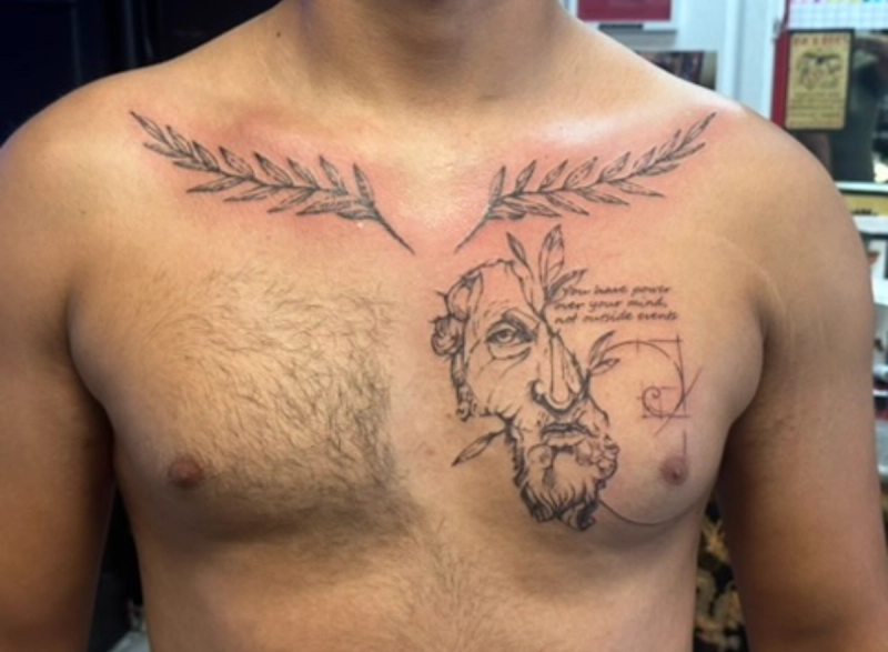 Black and grey illustrative tattoo with portrait and leafy branches on chest