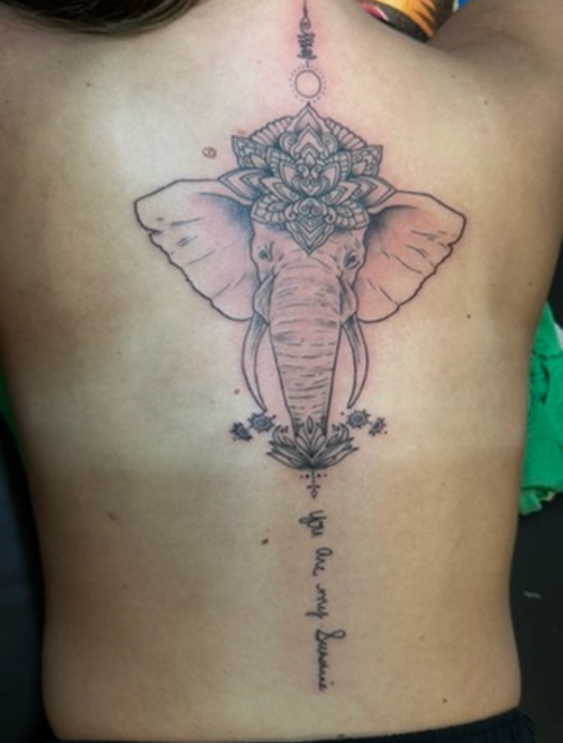 Black and grey geometric elephant head tattoo on upper back