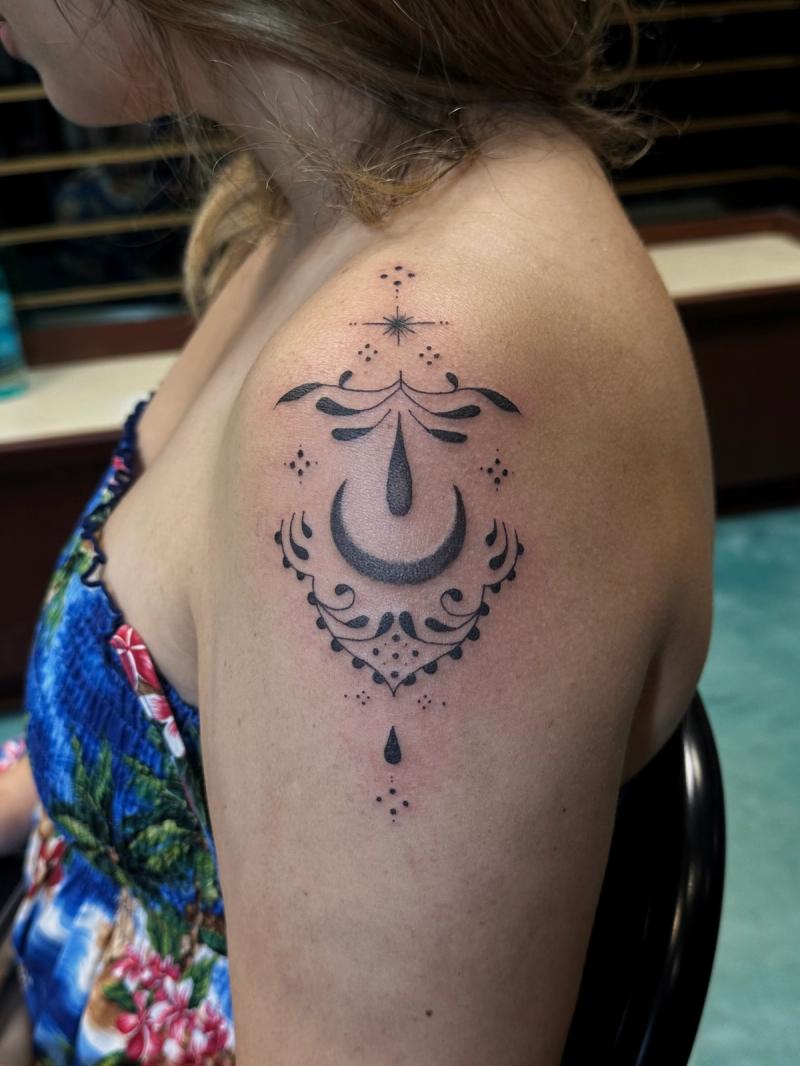 Black and grey geometric dotwork tattoo on upper arm