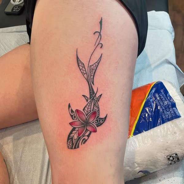 Colorful tribal floral tattoo on thigh