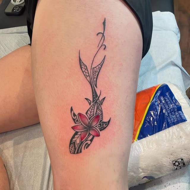 Colorful tribal floral tattoo on thigh