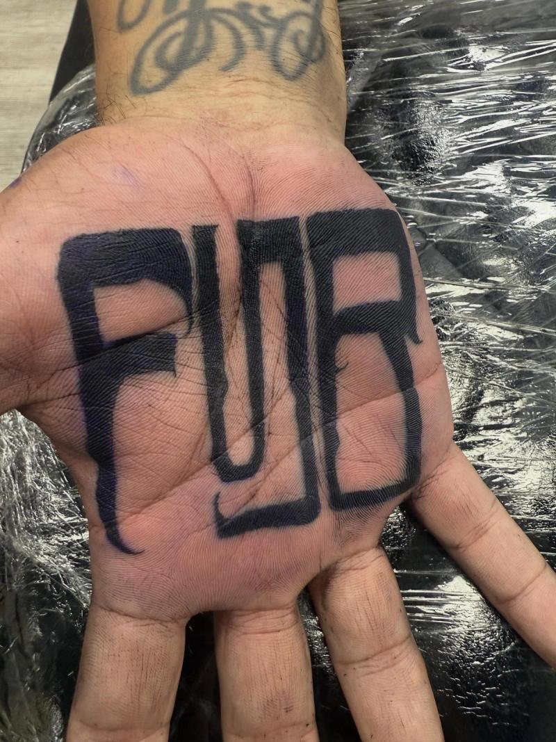 bold lettering tattoo on the palm