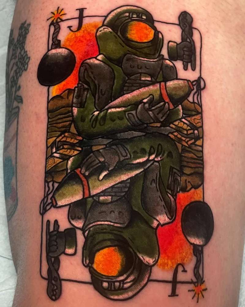 Colorful illustrative bomb suit card tattoo on upper arm