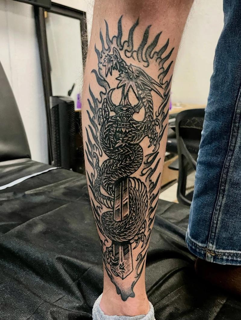 japanese dragon forearm tattoo with flames and sword