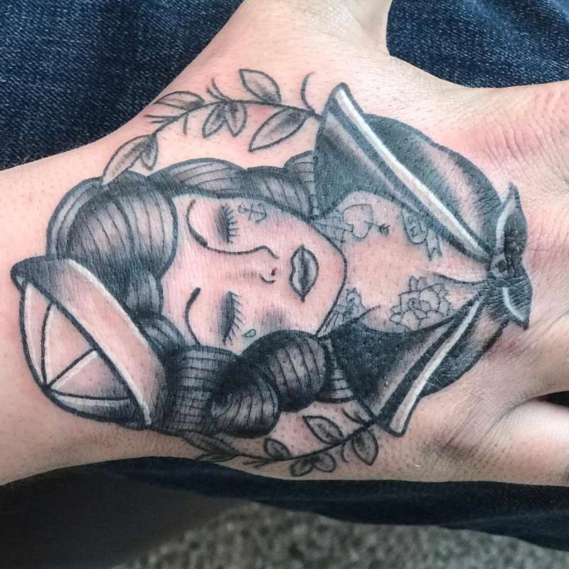 black and grey illustrative woman portrait tattoo on hand